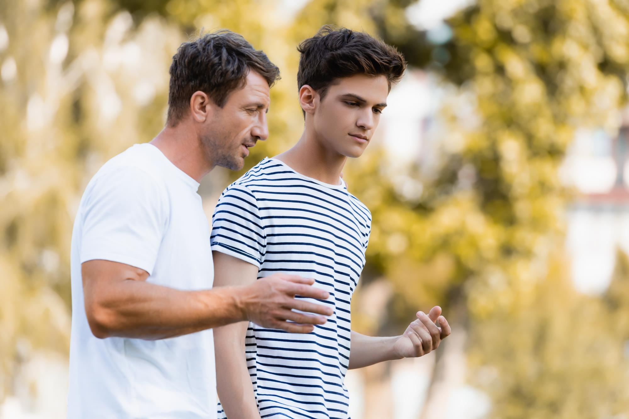 Teen boy talking to adult man